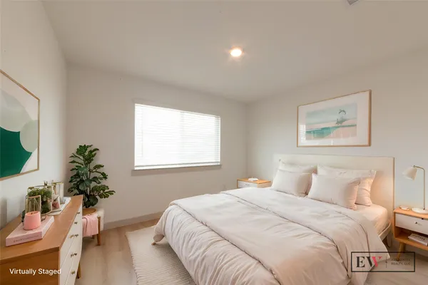 a bedroom with a large bed and a potted plant
