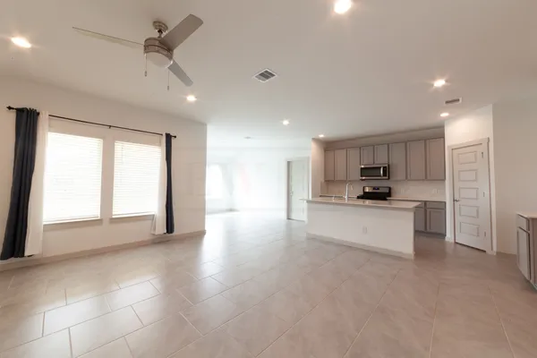 a large kitchen with kitchen island a sink a stove a refrigerator a center island a stove and a window