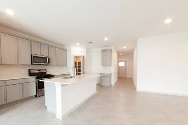 a large white kitchen with stainless steel appliances