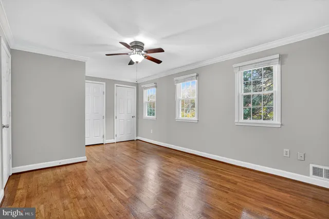 a view of an empty room with wooden floor