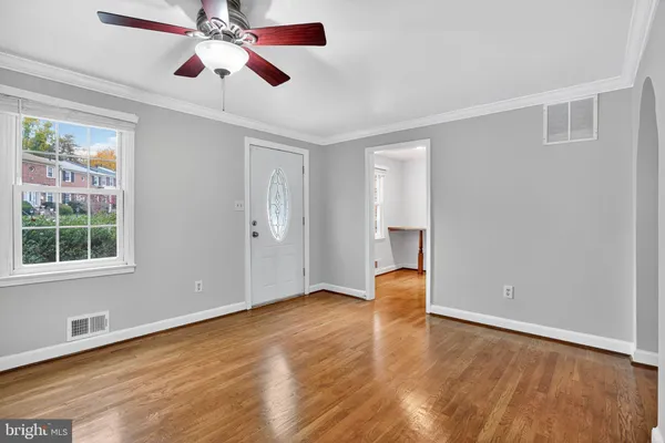 an empty room with wooden floor and entryway