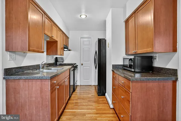 an empty room with wooden floor and cabinet