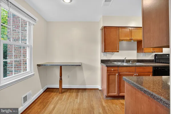 a view of a kitchen with wooden floor and staircase