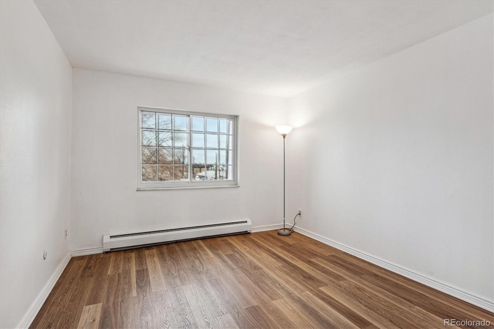 5770 East Warren Avenue, Unit 305 Denver, CO 80222 - Photo 14 of 24 an empty room with wooden floor and windows