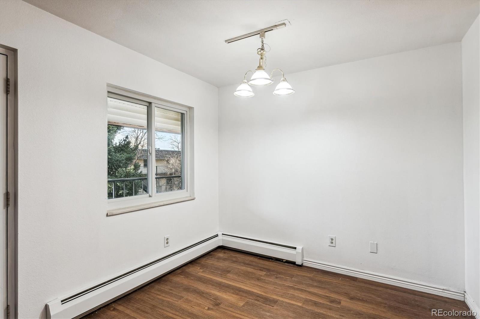 5770 East Warren Avenue, Unit 305 Denver, CO 80222 - Photo 4 of 24 an empty room with wooden floor and windows