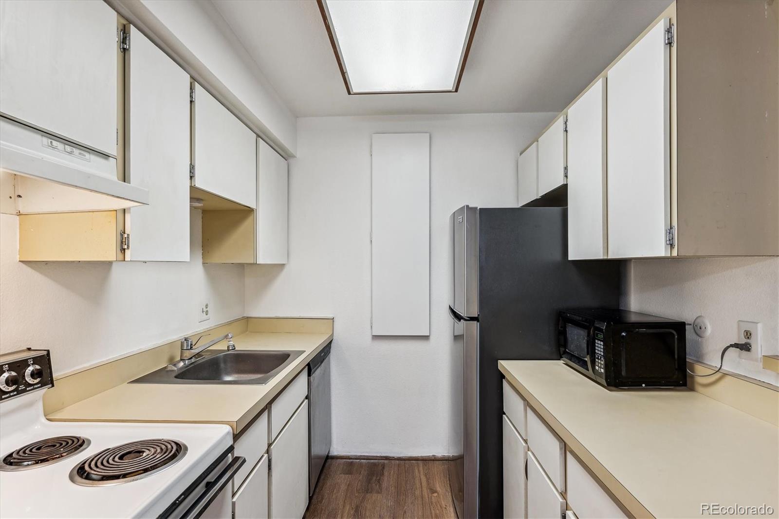 5770 East Warren Avenue, Unit 305 Denver, CO 80222 - Photo 6 of 24 a kitchen with a sink a stove and refrigerator