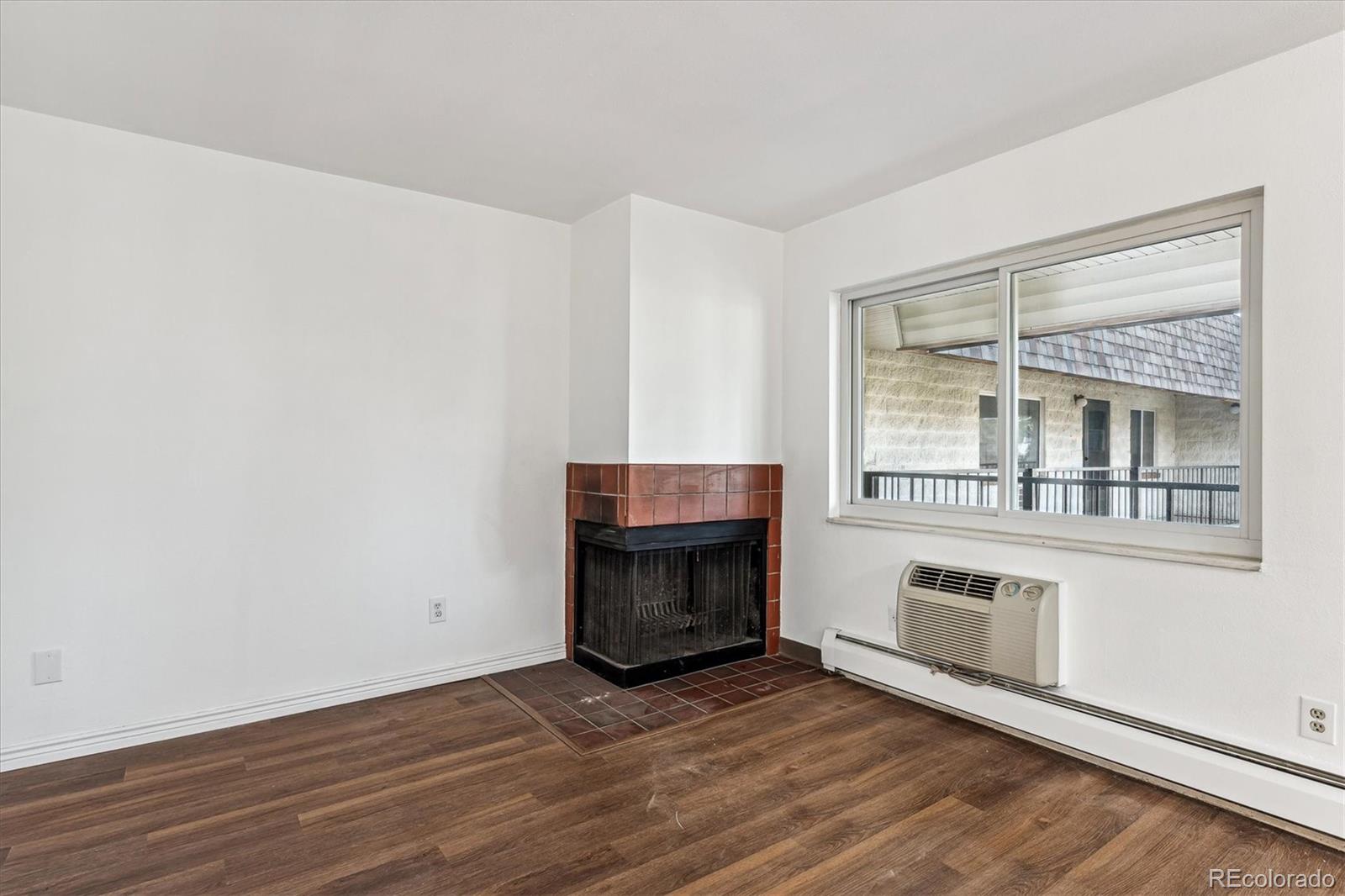 5770 East Warren Avenue, Unit 305 Denver, CO 80222 - Photo 8 of 24 a view of an empty room with wooden floor and a window