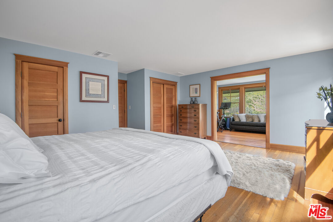 33208 Decker School Road Malibu, CA 90265 - Photo 18 of 51 a bedroom with a large bed and wooden floor