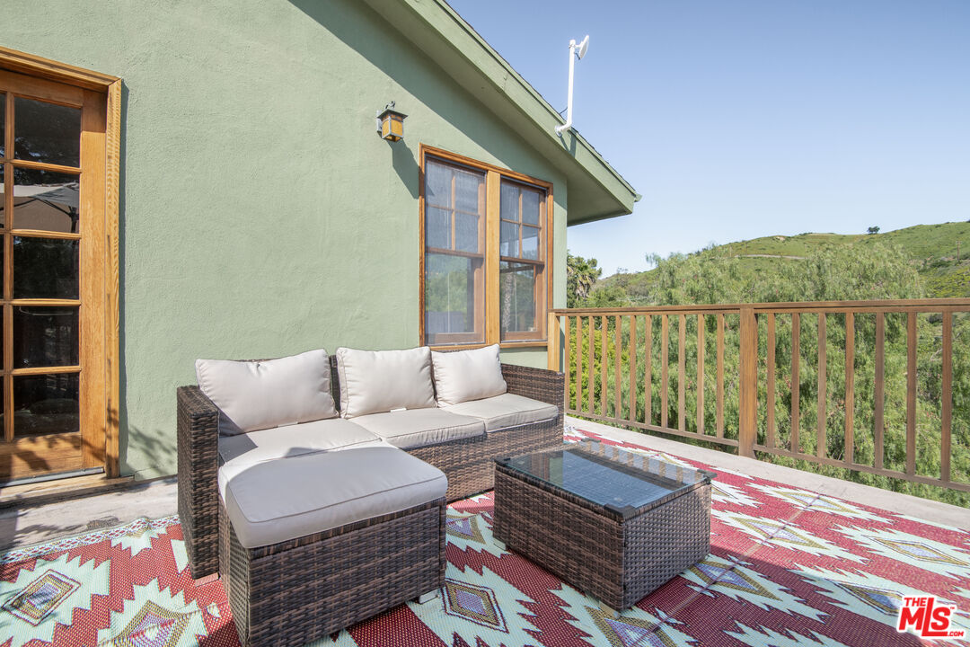 33208 Decker School Road Malibu, CA 90265 - Photo 21 of 51 a balcony with furniture and wooden floor