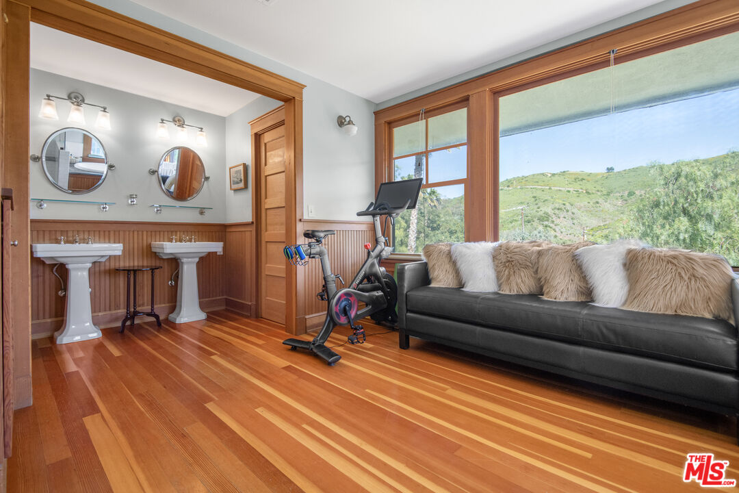 33208 Decker School Road Malibu, CA 90265 - Photo 24 of 51 a living room with furniture a fireplace and a floor to ceiling window