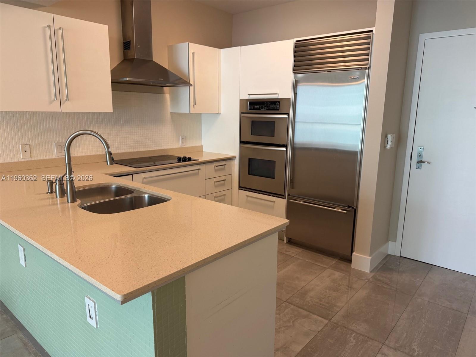 218 Southeast 14th Street, Unit 1406 Miami, FL 33131 - Photo 2 of 8 a kitchen with stainless steel appliances a refrigerator sink and stove