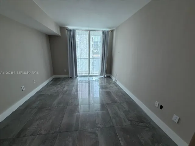 an empty room with an entryway and window