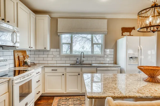 a bedroom with two beds and a dresser next to a window
