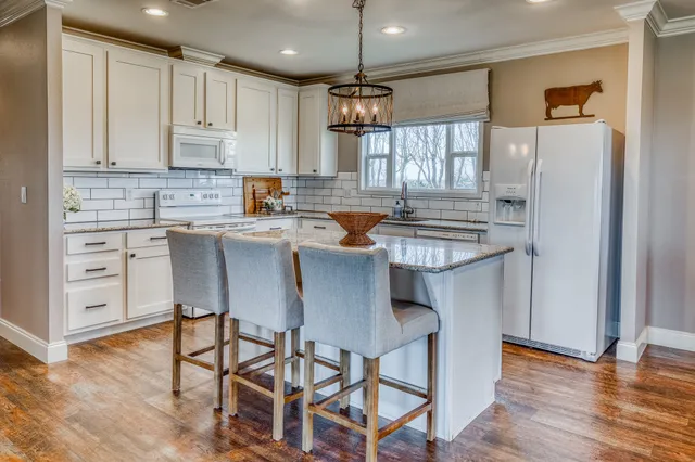 a bathroom with a granite countertop double vanity sink a mirror and a toilet