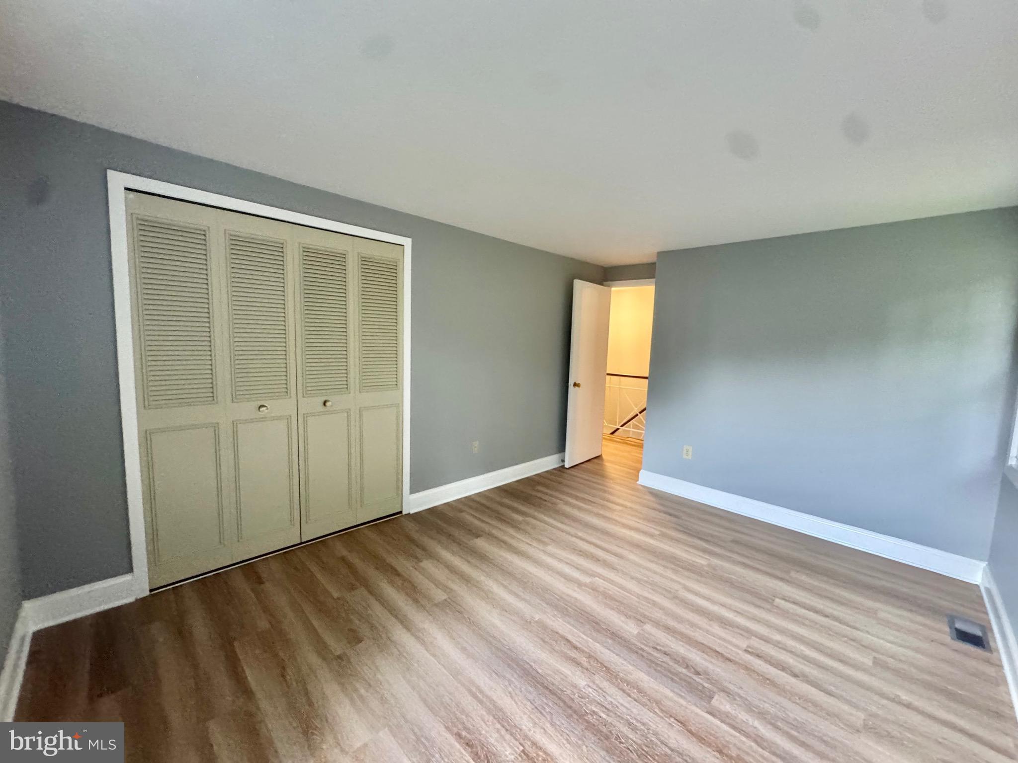 4908 Rocky Spring Lane Bowie, MD 20715 - Photo 28 of 36 an empty room with wooden floor and windows