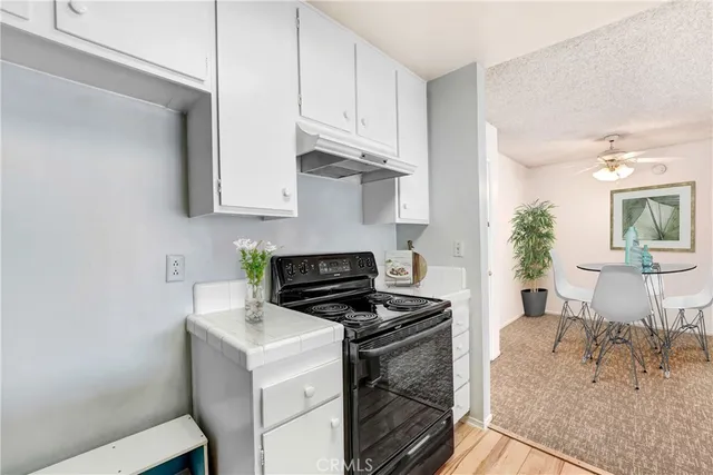 a kitchen with stainless steel appliances granite countertop a stove and a white cabinets