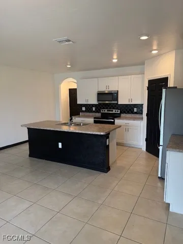 a kitchen with stainless steel appliances granite countertop a stove a sink and a refrigerator