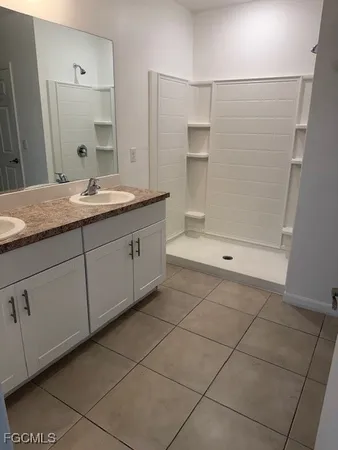 a bathroom with a granite countertop sink a mirror and a bathtub