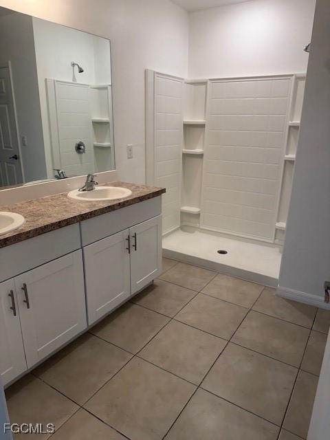8046 Gopher Tortoise Trail Lehigh Acres, FL 33972 - Photo 8 of 18 a bathroom with a granite countertop sink a mirror and a bathtub