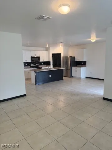 a large white kitchen with a stove top oven and cabinets
