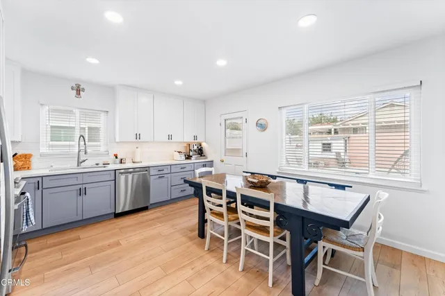 a kitchen with a table chairs sink and cabinets