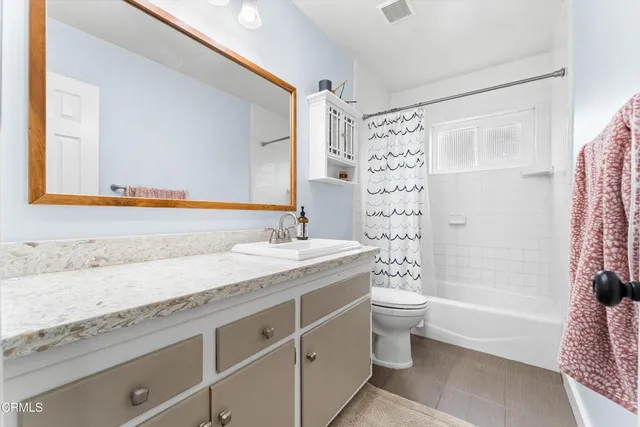 a bathroom with a granite countertop sink a toilet and shower