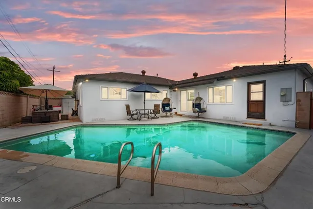 a view of a house with swimming pool and sitting area
