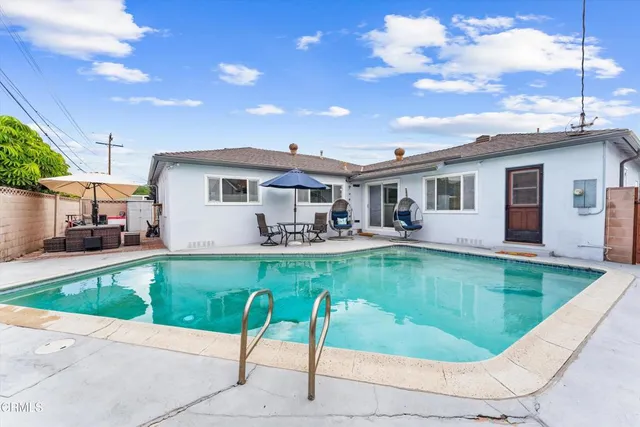 a view of a house with swimming pool and sitting area