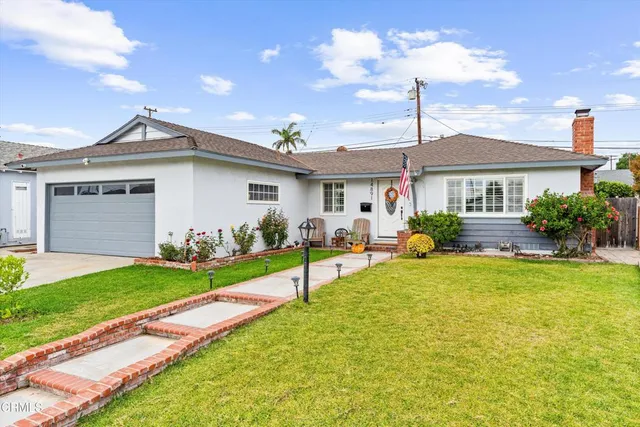 a view of an house with backyard and a tree