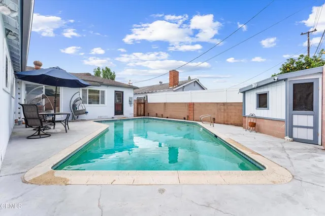 a view of backyard with swimming pool and seating area