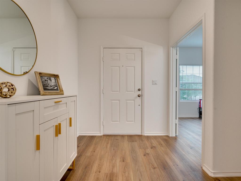 1208 Sweetspire Street Leander, TX 78641 - Photo 3 of 36 Entryway featuring wood-finish flooring, a paneled door, and neutral wall tones