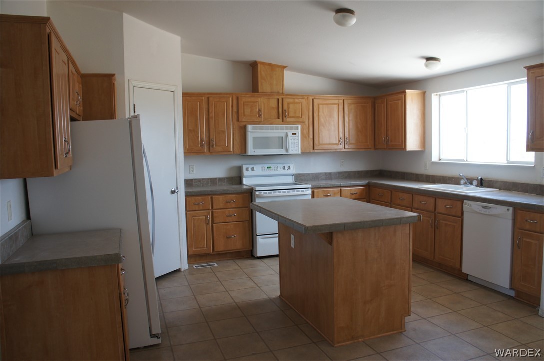 3233 West Rancho Road Golden Valley, AZ 86413 - Photo 11 of 33 a kitchen with a sink stove and refrigerator