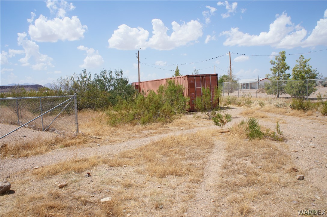 3233 West Rancho Road Golden Valley, AZ 86413 - Photo 6 of 33 a view of a dry yard with a large tree