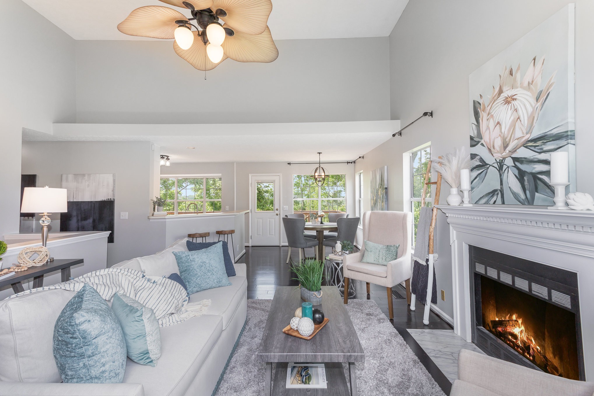 a living room with furniture a fireplace and a large window