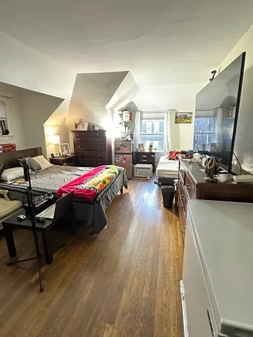 a bedroom with furniture and a wooden floor
