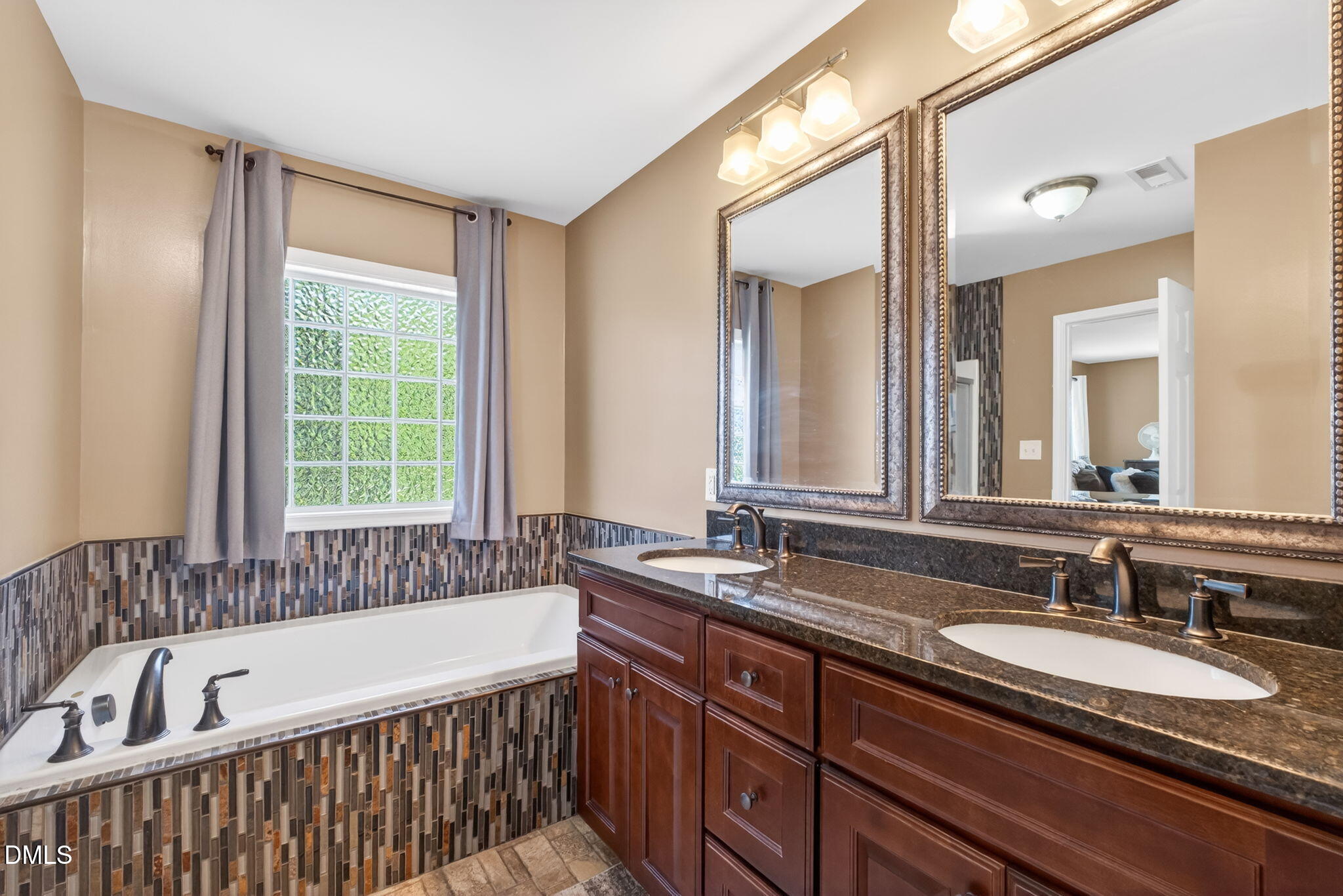 923 White Memorial Church Road Willow Spring, NC 27592 - Photo 27 of 46 a bathroom with a double vanity sink large mirror and a bathtub