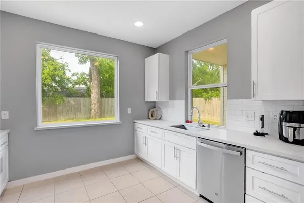 a kitchen with a sink window and cabinets