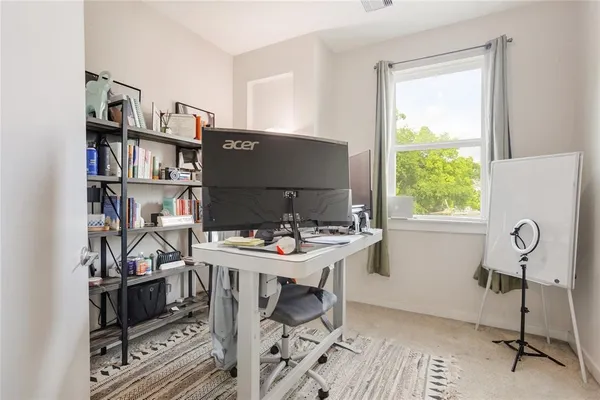 a view of a workspace with furniture and a window