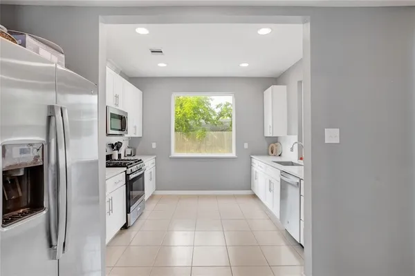 a kitchen with stainless steel appliances granite countertop a refrigerator and a stove