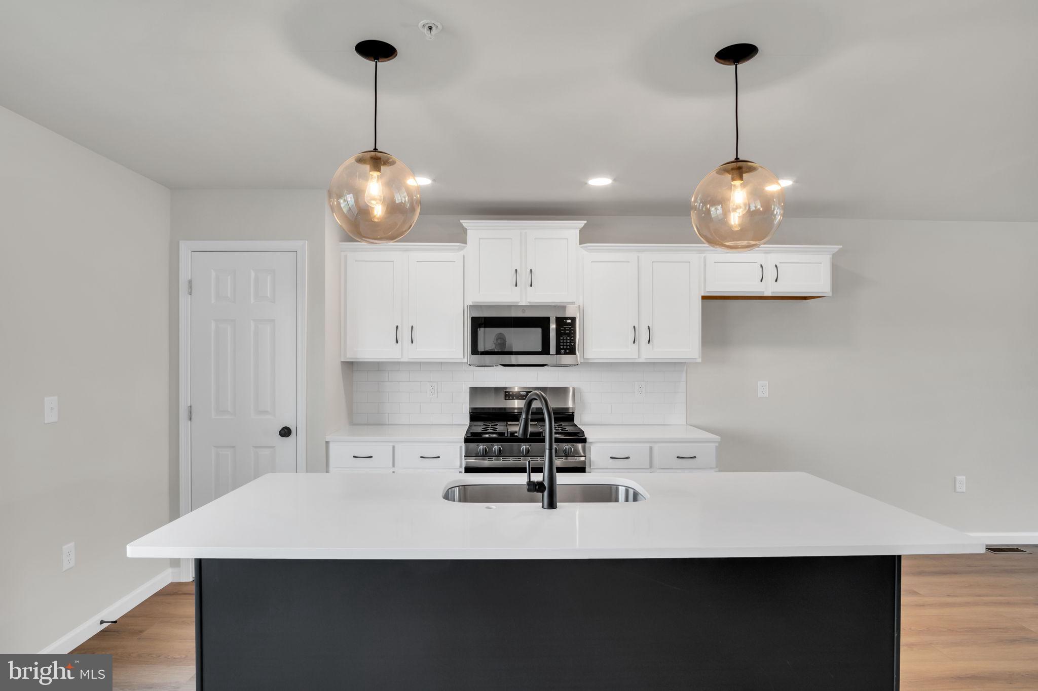 6 Morgan Drive, Unit 1203 Carlisle, PA 17015 - Photo 3 of 13 a kitchen with a sink a stove and kitchen island