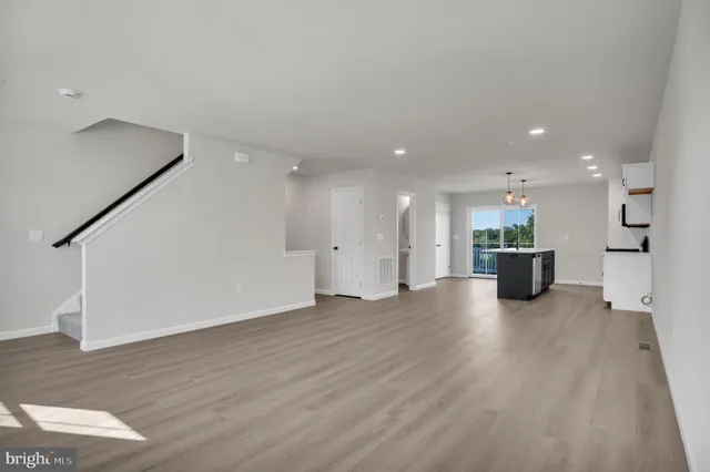 a view of a big room with wooden floor and windows