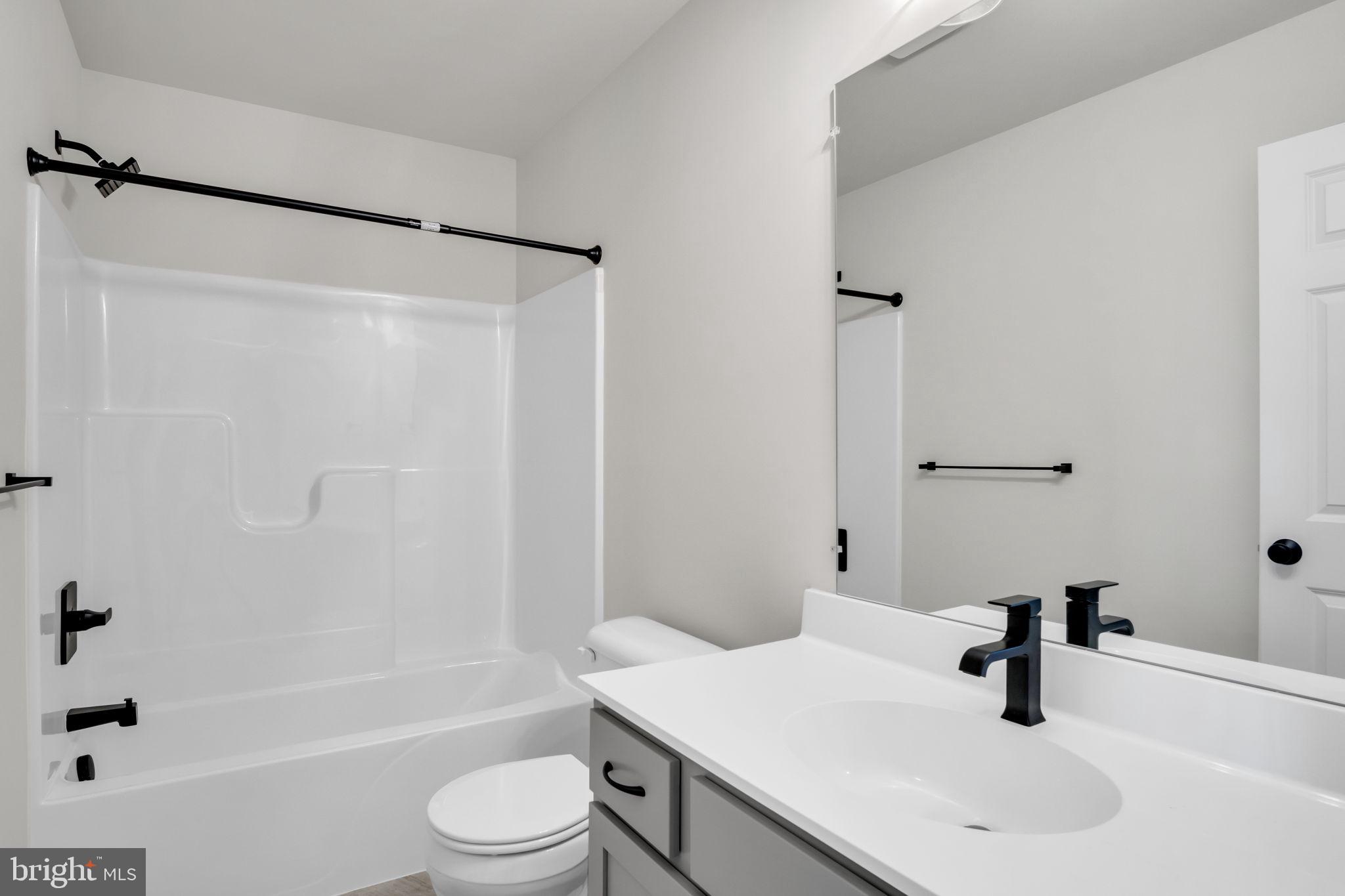 6 Morgan Drive, Unit 1203 Carlisle, PA 17015 - Photo 6 of 13 a bathroom with a sink a toilet a mirror and shower