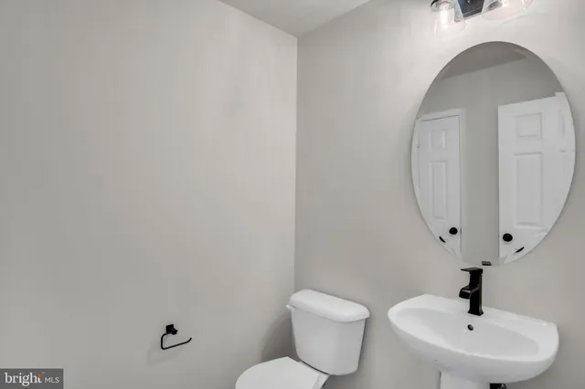 a bathroom with a sink a toilet a mirror and shower