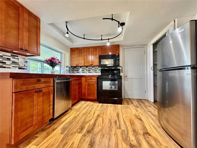 a kitchen with stainless steel appliances granite countertop a refrigerator and a sink