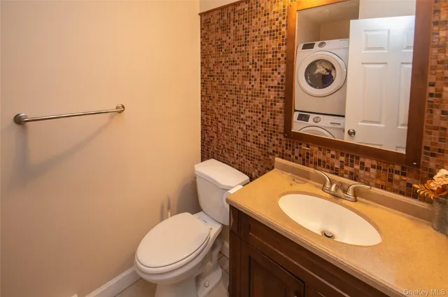a bathroom with a granite countertop toilet sink and mirror