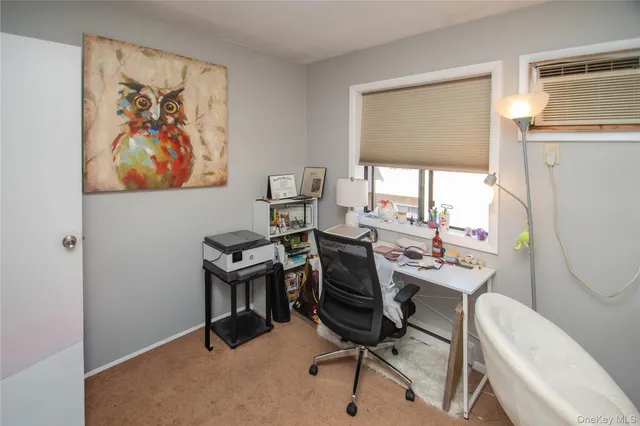 a view of a workspace with furniture and a window