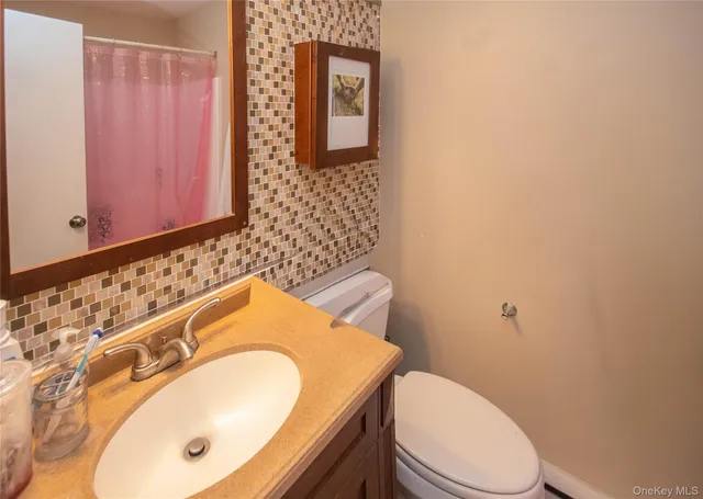 a bathroom with a sink a toilet and mirror
