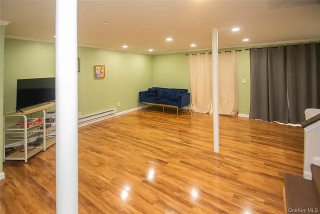 a view of a livingroom with kitchen space and wooden floor