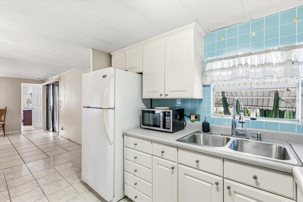 1960 Pinewood Lane Mount Dora, FL 32757 - Photo 3 of 12 a kitchen with white cabinets and refrigerator