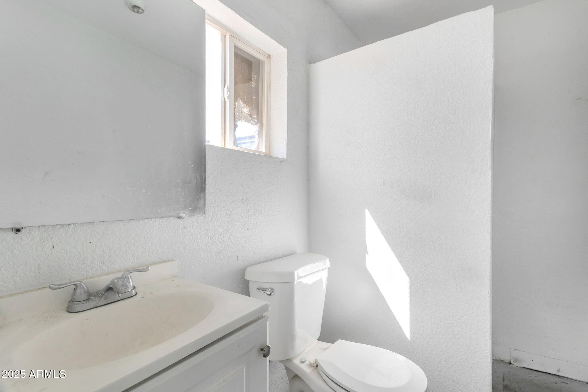 313 West Jones Avenue Phoenix, AZ 85041 - Photo 15 of 28 a white toilet sitting next to a bathroom sink